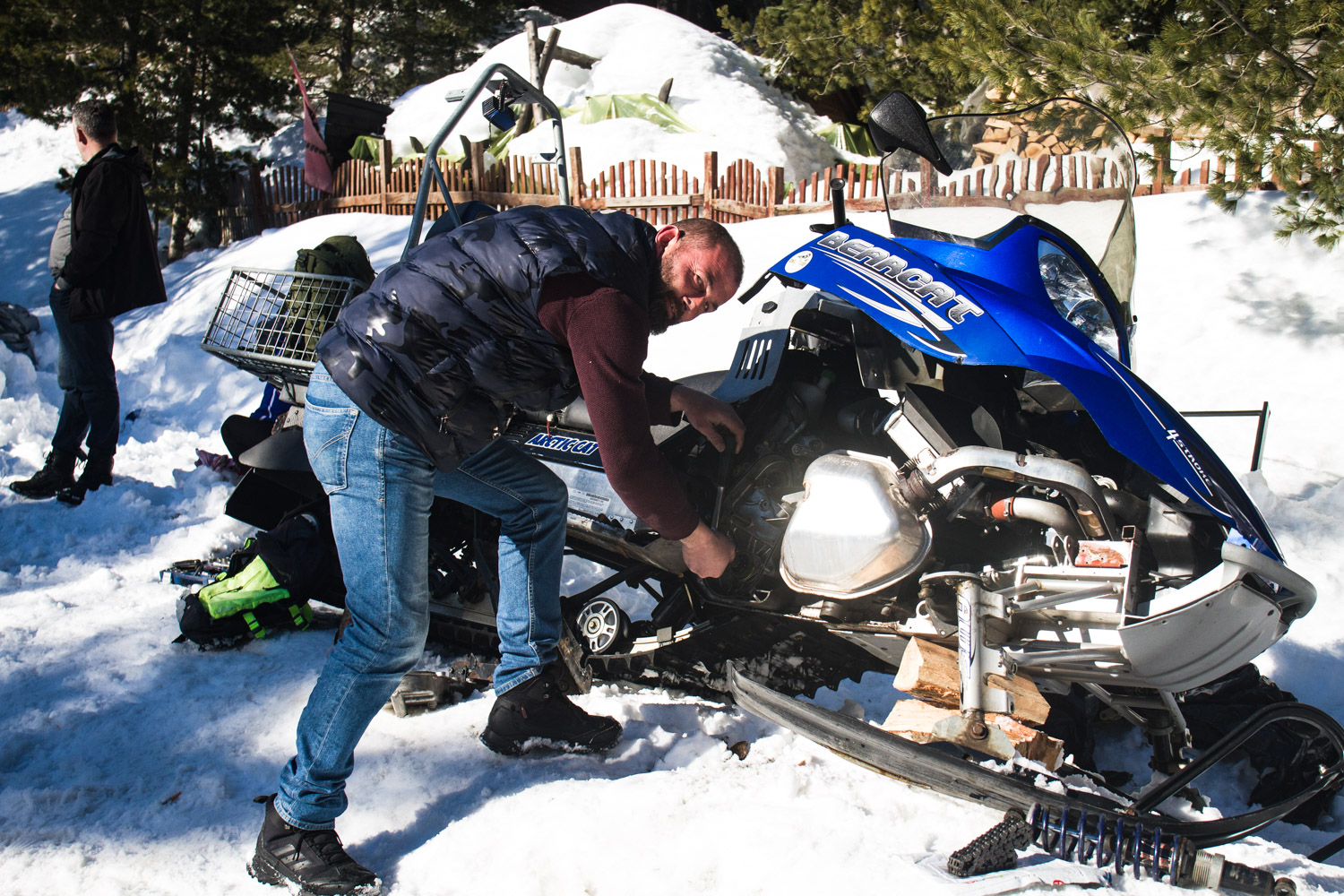 Man fixing snowmobile