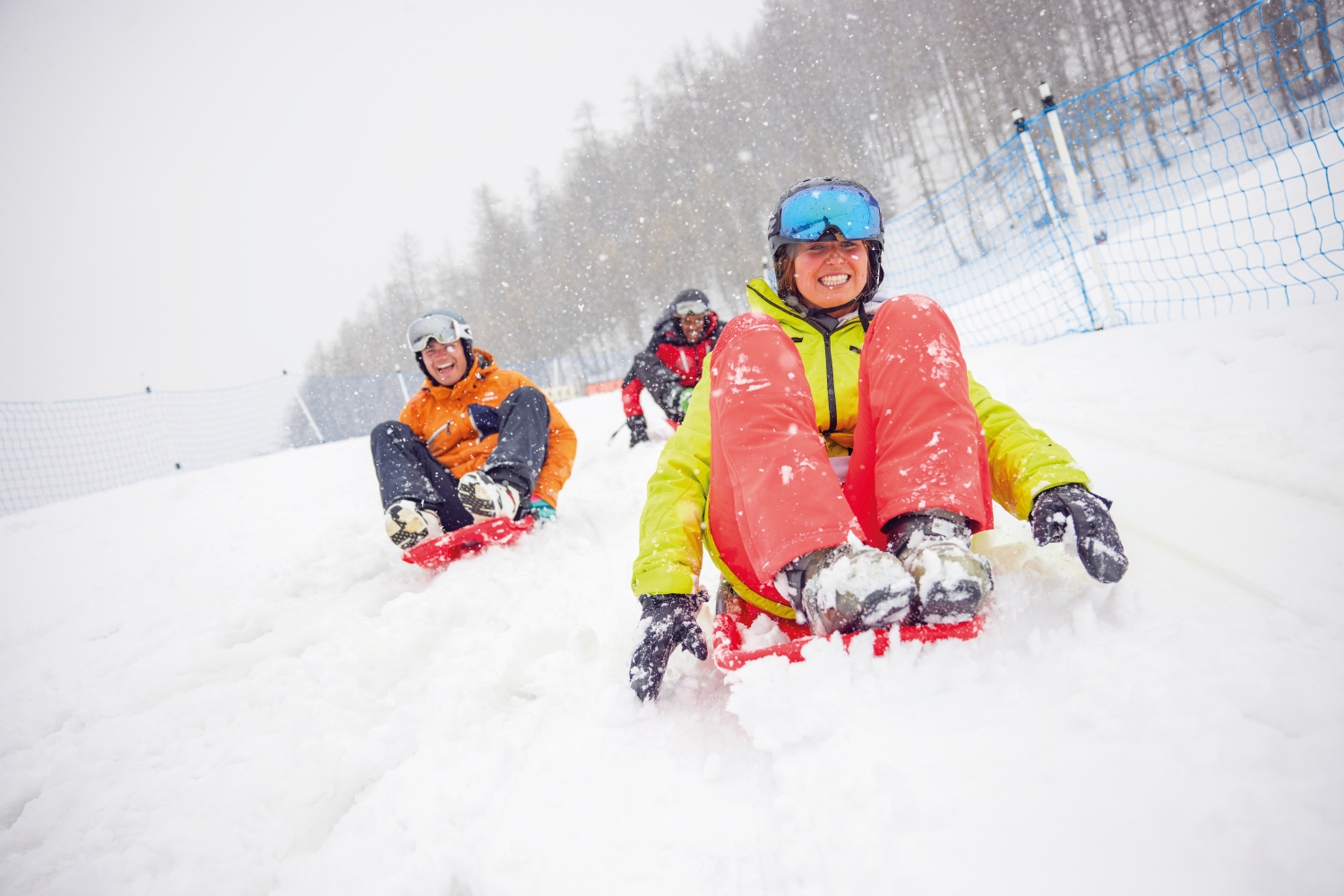 People sledding down snowy hill