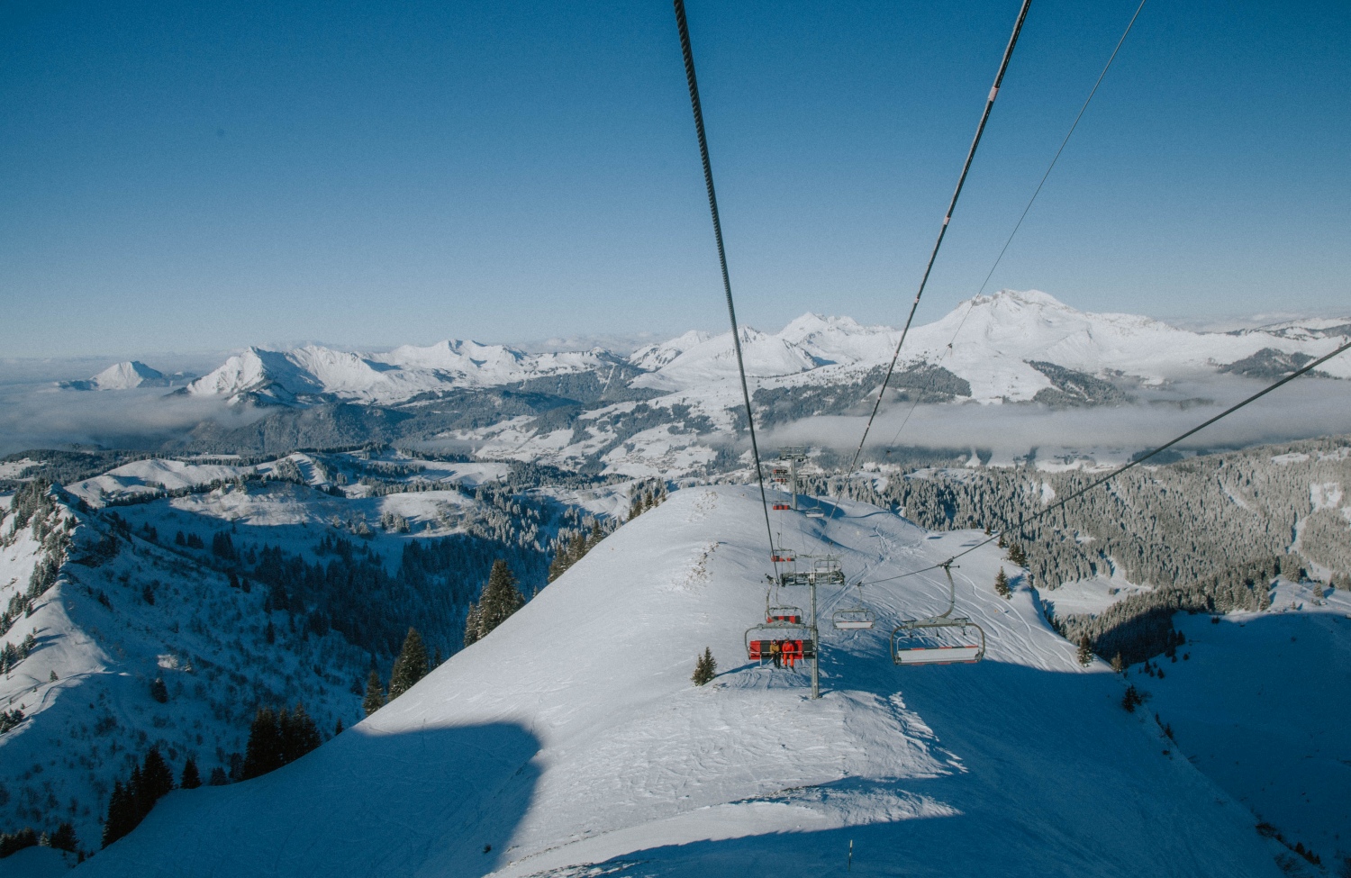 Photo from ski lift looking out over snow covered mountains