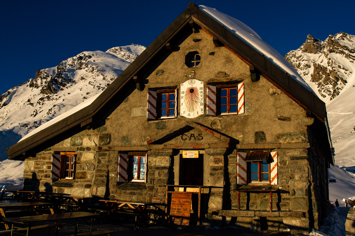 Stone building next to snow covered mountains